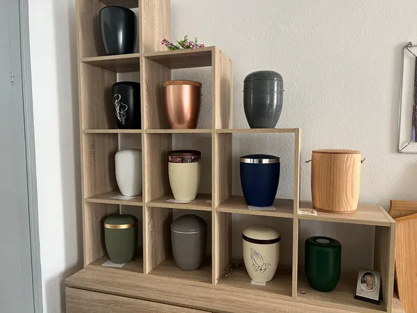 Würfelregal mit Urnen in Schwarz, Kupfer, Weiß, Blau, Grün und hellem Holz
